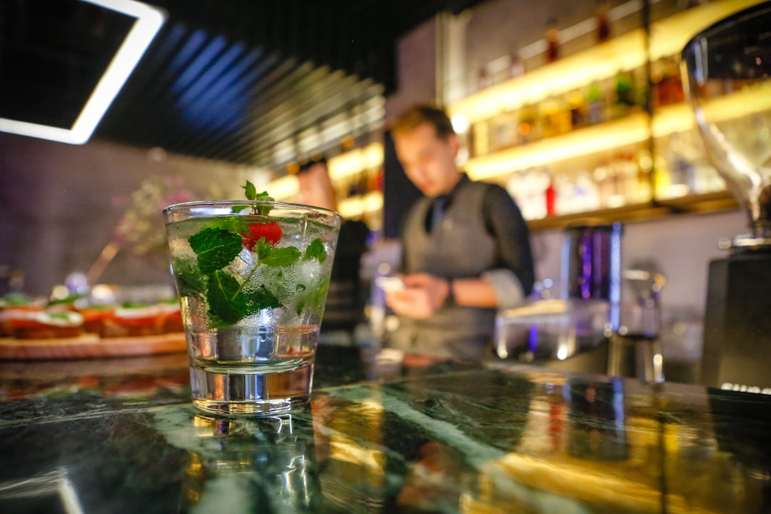 a-person-standing-behind-a-glass-of-water-with-a-straw-in-it-z7cyghchx90